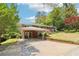 Brick home with a covered parking area, landscaped lawn, and brick retaining wall, all under a bright sky at 454 Jo Ann Se Dr, Marietta, GA 30067