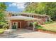 Features a charming brick exterior, covered carport, landscaped yard, and a welcoming staircase leading to the entrance at 454 Jo Ann Se Dr, Marietta, GA 30067