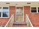 Features a secure storm door with decorative ironwork, set against a classic brick facade and manicured landscaping at 454 Jo Ann Se Dr, Marietta, GA 30067