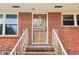 Shows the brick facade with a secure storm door with decorative ironwork and manicured landscaping at 454 Jo Ann Se Dr, Marietta, GA 30067