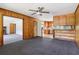 Living room featuring wood paneling, a ceiling fan, and an open view into the kitchen area at 454 Jo Ann Se Dr, Marietta, GA 30067