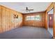 Living room with wood paneled walls, carpeted floors, ceiling fan, and natural light at 454 Jo Ann Se Dr, Marietta, GA 30067