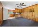 Wood-paneled living room with a ceiling fan and view into the kitchen with light wood cabinets at 454 Jo Ann Se Dr, Marietta, GA 30067