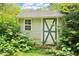 Charming shed with a unique door design, surrounded by lush greenery in the backyard at 454 Jo Ann Se Dr, Marietta, GA 30067