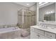 Bright bathroom with double sink vanity, soaking tub, and glass enclosed shower at 552 Micayne Se Cir # 1, Smyrna, GA 30082