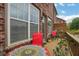 Outdoor patio with red chairs, a decorative table, potted plants, and a view of the brick exterior at 552 Micayne Se Cir # 1, Smyrna, GA 30082
