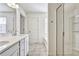 Bright bathroom featuring double sinks, a glass shower, and a soaking tub at 2240 Mulsanne Dr, Lithonia, GA 30058