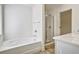 Elegant bathroom features a soaking tub, glass enclosed shower, and tile floor at 2240 Mulsanne Dr, Lithonia, GA 30058