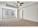 Bright bedroom features a tray ceiling, ceiling fan, carpet and lots of natural light at 2240 Mulsanne Dr, Lithonia, GA 30058