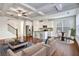 Bright, open-concept living room showcasing modern kitchen, coffered ceilings, and elegant hardwood floors at 2240 Mulsanne Dr, Lithonia, GA 30058