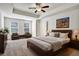 Well-lit main bedroom boasts a tray ceiling with fan, seating area, and wood furniture at 2240 Mulsanne Dr, Lithonia, GA 30058