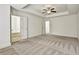 Spacious main bedroom with bathroom featuring a tray ceiling and open doorway at 2240 Mulsanne Dr, Lithonia, GA 30058