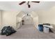 Cozy attic space with neutral carpet and paint, ceiling fan, and natural light from the window at 552 Trotters Ln, Mcdonough, GA 30252