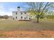 View of a home's backyard with a large patio, grill, and spacious lawn surrounded by trees at 552 Trotters Ln, Mcdonough, GA 30252