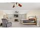 Bright bedroom featuring a fireplace, ceiling fan, and plush carpet, bathed in natural light from multiple windows at 552 Trotters Ln, Mcdonough, GA 30252
