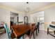 Bright dining room with an elegant chandelier, wainscoting, and an open-concept design at 552 Trotters Ln, Mcdonough, GA 30252