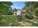 Picturesque view of the home's exterior, set amidst a sprawling green lawn and mature trees at 5623 Yeager Dr, Douglasville, GA 30135