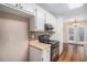 Galley kitchen features wooden floors, painted cabinets, and black appliances at 5623 Yeager Dr, Douglasville, GA 30135