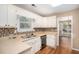 Well-lit kitchen with white cabinets, mosaic backsplash, and modern appliances at 5623 Yeager Dr, Douglasville, GA 30135