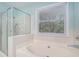 Bathroom boasts a tub, glass shower, and bright window with natural light at 5623 Yeager Ridge Dr, Douglasville, GA 30135