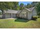 Charming single-story home with a landscaped front yard, gray siding, and a red front door at 5623 Yeager Ridge Dr, Douglasville, GA 30135