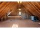 Unfinished attic featuring exposed wood rafters, insulation, natural light, and some installed appliances at 168 Jersey Rd, Oxford, GA 30054