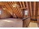 Unfinished attic with exposed wood rafters, insulation, and natural light from the windows at 168 Jersey Rd, Oxford, GA 30054