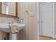Charming powder room with pedestal sink and decorative wallpaper at 168 Jersey Rd, Oxford, GA 30054