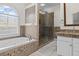 Elegant bathroom featuring a soaking tub, tiled shower, and granite countertops at 168 Jersey Rd, Oxford, GA 30054