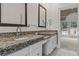 Bathroom featuring granite countertops, dual sinks, and access to outdoor living at 168 Jersey Rd, Oxford, GA 30054