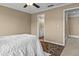 Cozy bedroom featuring neutral paint, ceiling fan, and doorway to an adjoining bathroom at 168 Jersey Rd, Oxford, GA 30054