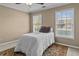 Bedroom with a queen size bed, ceiling fan, and lots of natural light from two windows at 168 Jersey Rd, Oxford, GA 30054