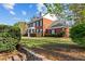 Charming two-story brick home featuring manicured lawn, dormer windows, and lush landscaping at 168 Jersey Rd, Oxford, GA 30054