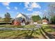 Rear view of home with brick and white siding, plus lush backyard and circular driveway at 168 Jersey Rd, Oxford, GA 30054