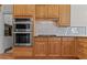 Modern kitchen with built-in stainless steel double ovens and granite countertops at 168 Jersey Rd, Oxford, GA 30054