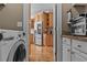 Functional laundry room adjacent to the kitchen, featuring stainless steel appliances and granite countertops at 168 Jersey Rd, Oxford, GA 30054