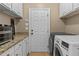 Functional laundry room with cabinetry, granite countertops, and modern washer/dryer at 168 Jersey Rd, Oxford, GA 30054