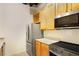 Cozy kitchen featuring stainless steel microwave and refrigerator, and blonde wood cabinetry at 32 Peachtree Nw St # 1303, Atlanta, GA 30303