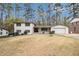 Charming two-story home with a white brick exterior and a well-manicured front yard with mature trees at 3221 Goldenchain Dr, Lithonia, GA 30038