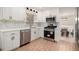 Well-equipped kitchen with white cabinets, stainless steel appliances, and a view to the dining area at 3221 Goldenchain Dr, Lithonia, GA 30038