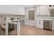 Upstairs kitchenette featuring white cabinets and stainless steel appliances and wood look tile flooring at 3221 Goldenchain Dr, Lithonia, GA 30038