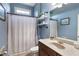 Stylish bathroom with blue walls, a shower, a vanity with mirror and modern fixtures at 4514 Heathrow Nw Ct, Kennesaw, GA 30152