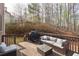 Relaxing outdoor deck with wicker sofa, grill, and view of the backyard's wooded area at 4514 Heathrow Nw Ct, Kennesaw, GA 30152