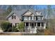 Charming two-story brick home featuring a welcoming front porch and manicured landscaping, surrounded by mature trees at 4514 Heathrow Nw Ct, Kennesaw, GA 30152