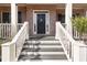 Inviting front porch steps lead to a brick facade with a dark front door and white railings at 4514 Heathrow Nw Ct, Kennesaw, GA 30152