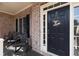 Covered front porch features a welcoming black front door, classic brickwork, and rocking chairs at 4514 Heathrow Nw Ct, Kennesaw, GA 30152