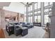 Spacious living room featuring high ceilings, a brick accent wall, and an abundance of natural light from large windows at 4514 Heathrow Nw Ct, Kennesaw, GA 30152