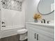 Well-lit bathroom features a modern vanity, sleek fixtures, and a tiled shower-tub combination at 490 Third Ave, Scottdale, GA 30079