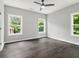 Bright bedroom features hardwood floors, a modern ceiling fan, and large windows offering ample natural light at 490 Third Ave, Scottdale, GA 30079