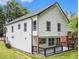 Rear exterior view of a modern home featuring a deck with black railings and a well-maintained lawn at 490 Third Ave, Scottdale, GA 30079